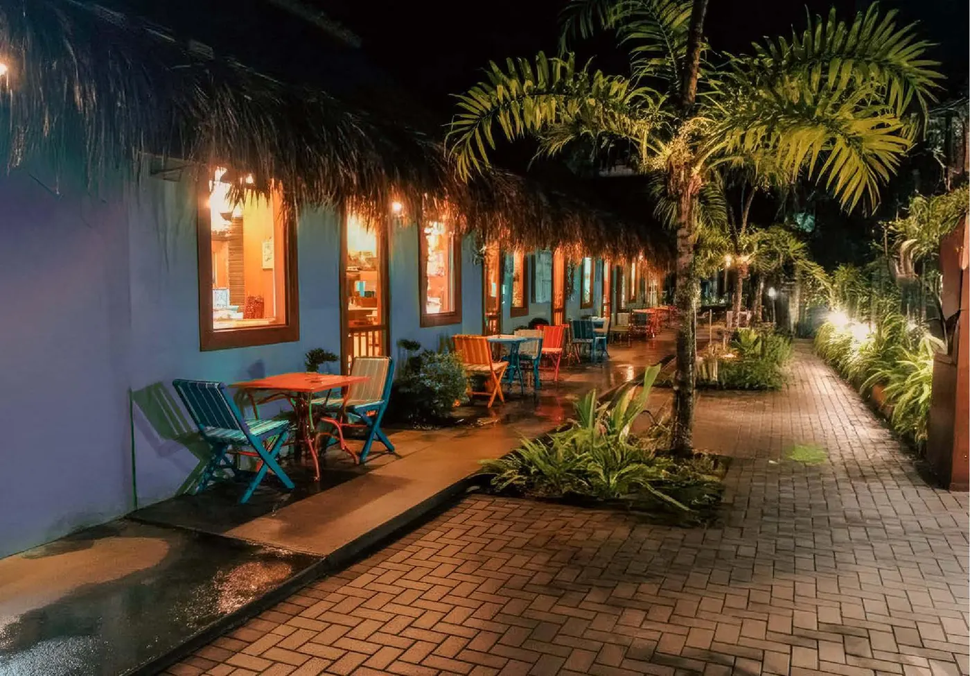 Vila local iluminada à noite, com restaurantes e vida local autêntica
